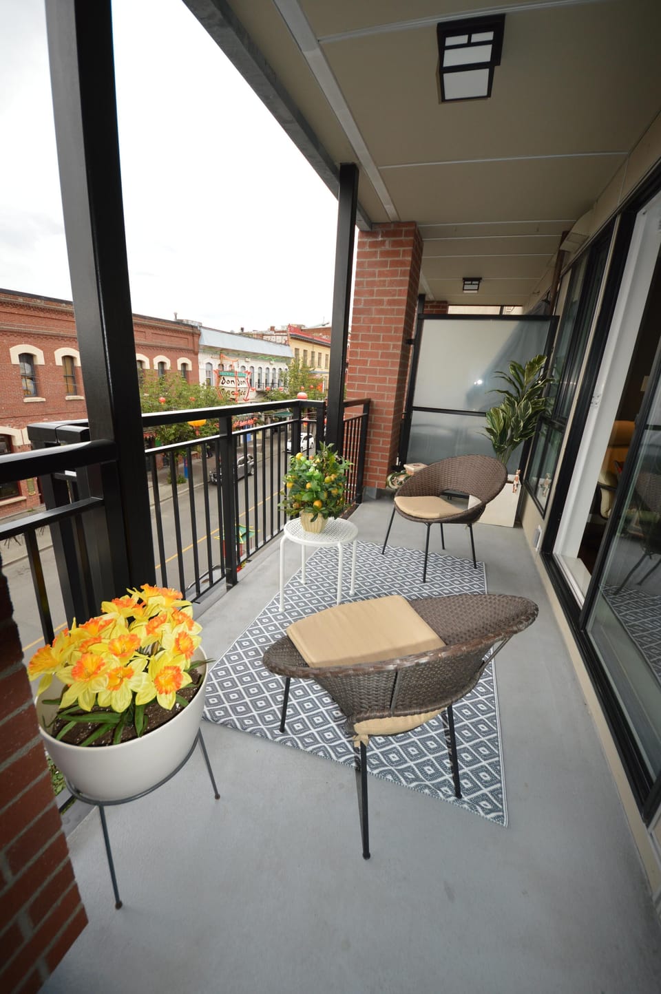 Alternate angle of the long covered balcony showing the outdoor seating area and streetscape views.