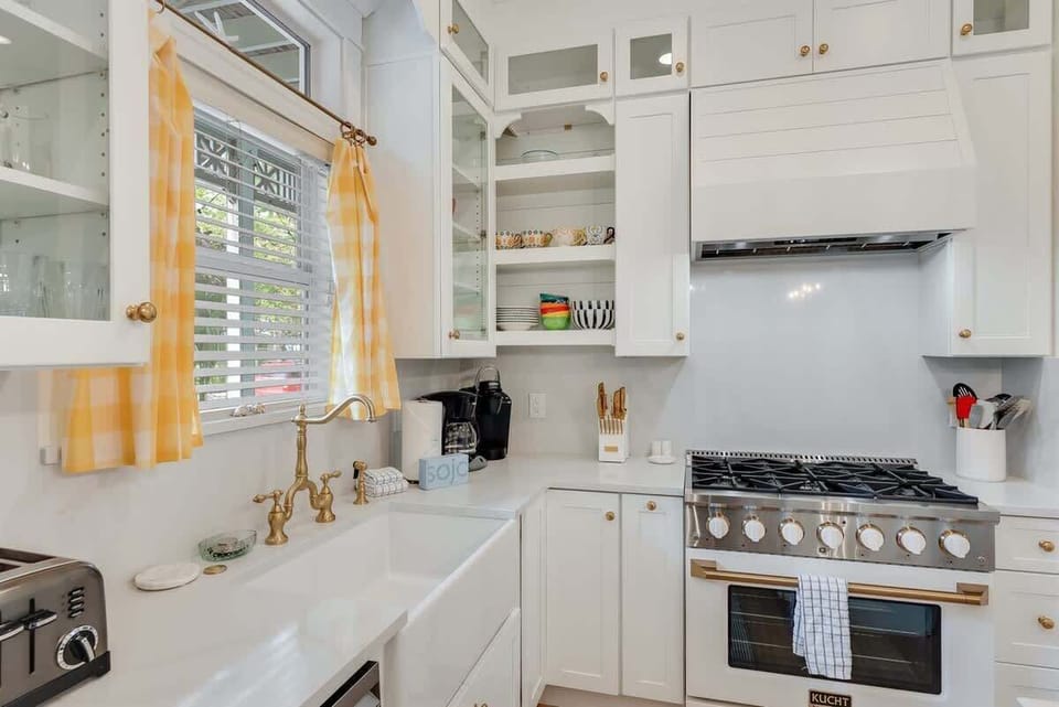 - Farmhouse sink with brass hardware blends beauty and function for easy kitchen cleanup - Gas range with vent hood is perfect for everything from simple breakfasts to full dinners - Open shelving adds charm and keeps essentials within reach