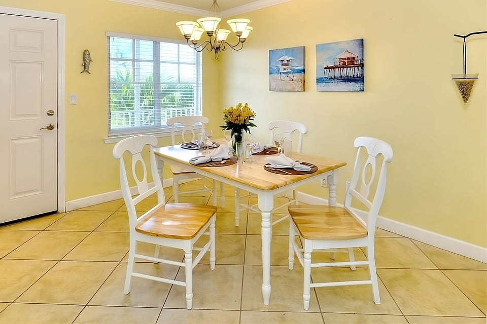 Gather for relaxed meals under warm lighting and coastal art.