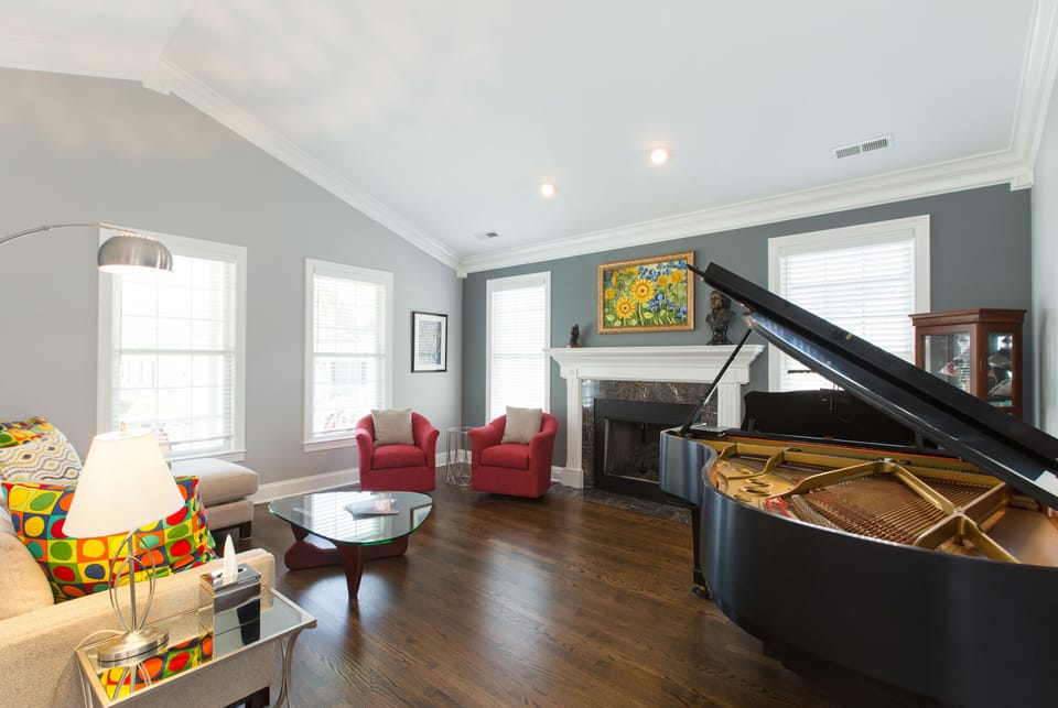 living room with grand piano and gas fireplace