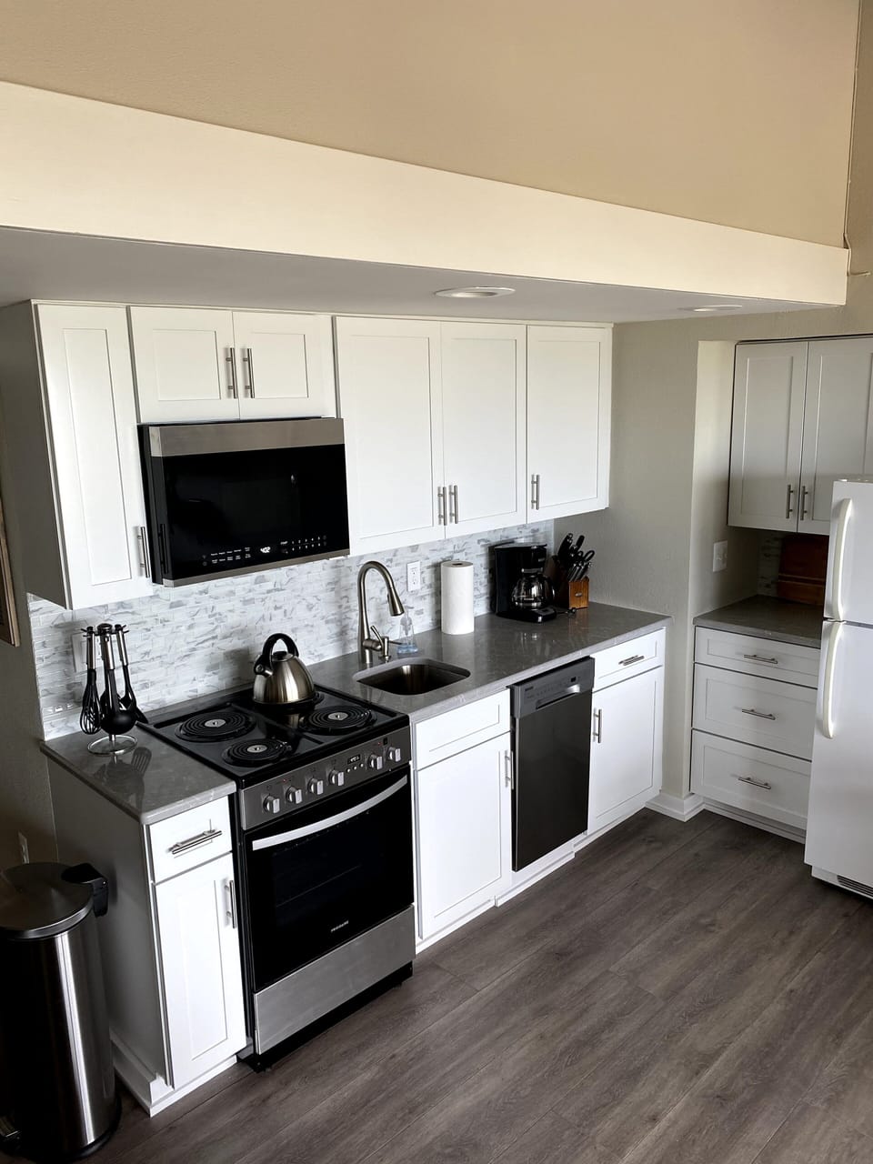 Updated kitchen with new cabinets, countertops, backsplash, paint,  & appliances