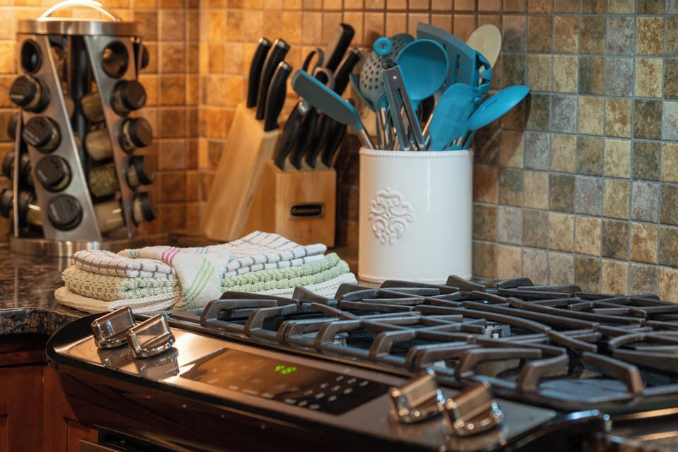 - Fully equipped kitchen features a modern gas stove and full utensil set - Ceramic holder and knife block keep essentials organized and ready - Stone tile backsplash and folded linens add charm to this cozy corner