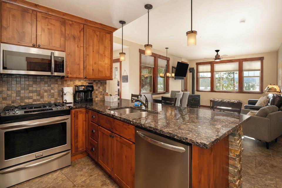 - Gourmet kitchen with granite countertops, gas stove, and stainless appliances - Pendant lighting and warm wood cabinetry create a rustic modern look - Open layout connects to dining and living areas for effortless hosting