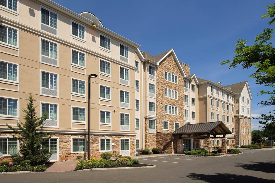 Multi-story hotel exterior with stone facade and landscaping.
