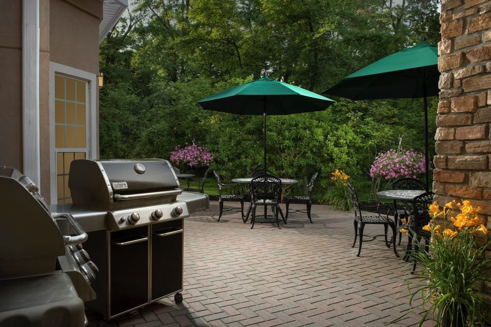 Outdoor patio with gas grill and seating area.