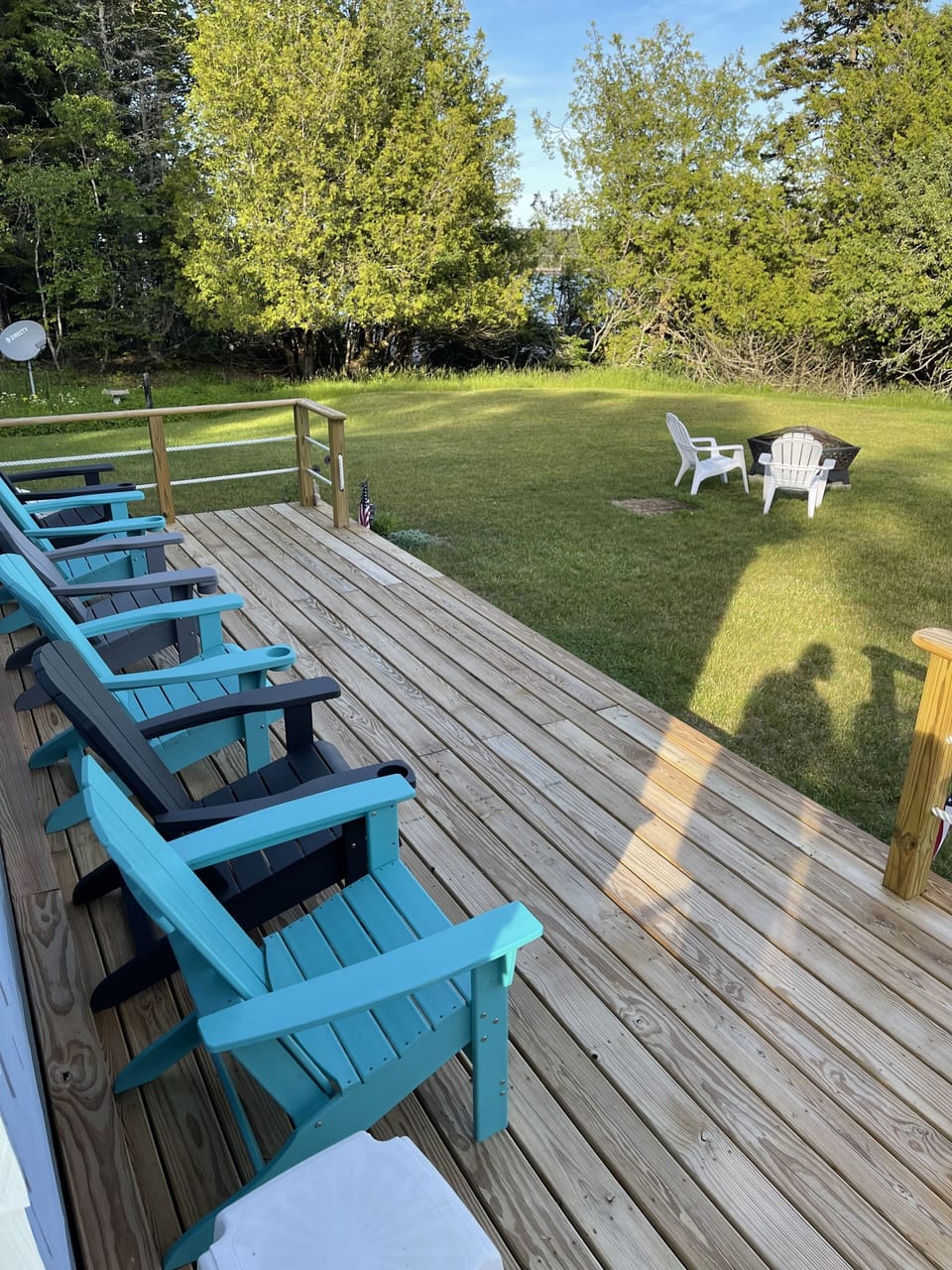 small porch with comfy chairs, fire pit and a nice view of the bay