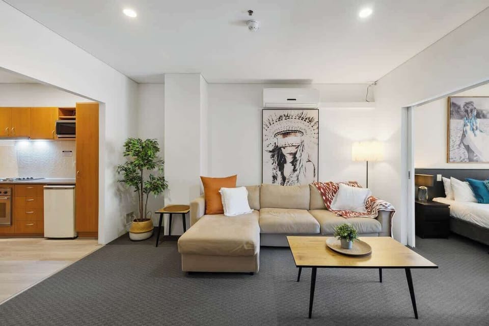 Relax in our cozy living area with a spacious sofa, unique artwork, and easy access to the kitchen and bedroom. It’s the perfect space to feel at home.