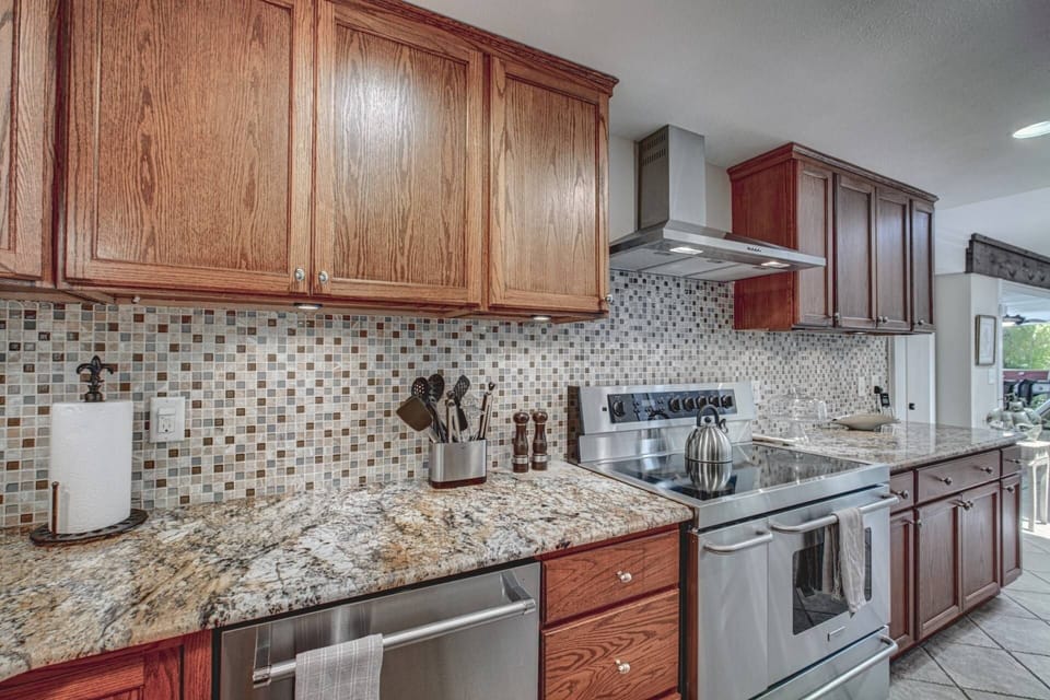 High end stainless appliances and solid natural stone counters.  Oven has 5 burners and a warming cave.
