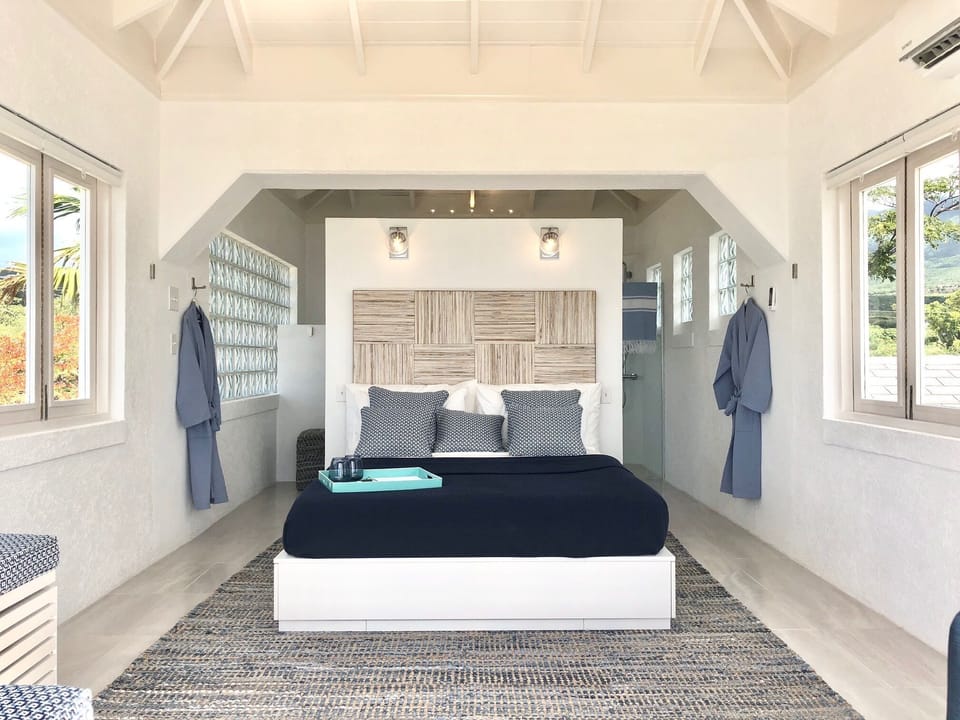 The queen size bed from the main bedroom. The bathroom is behind the bed wall.