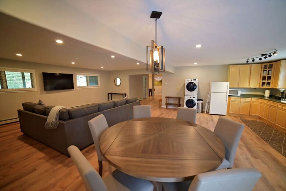 Lower level living room, kitchen, and dining including a secondary washer and dryer.