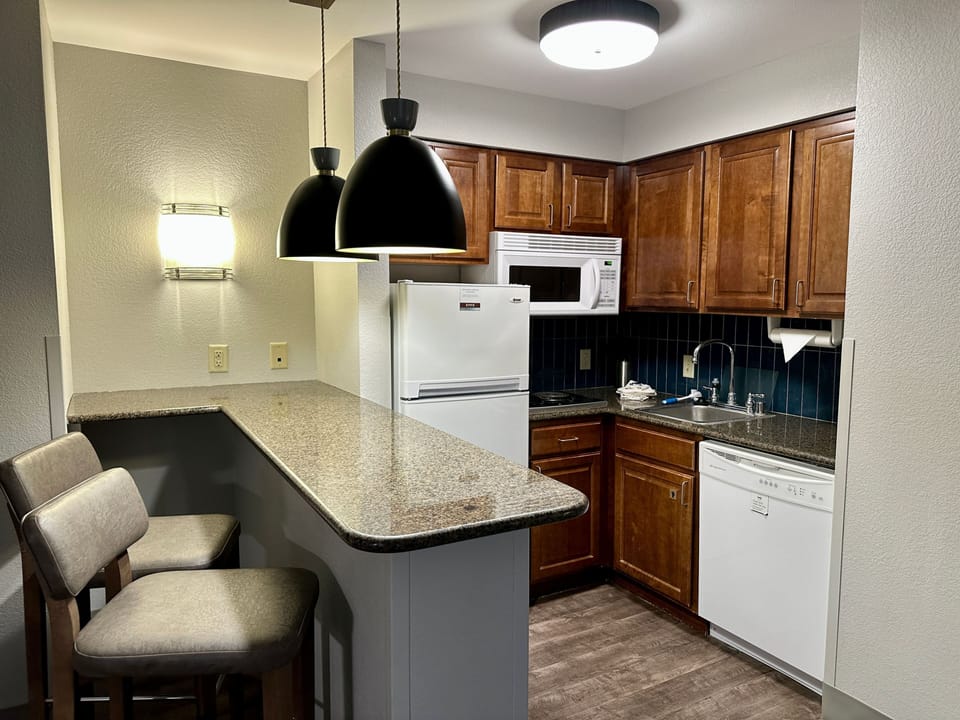 Modern kitchen with granite countertop and full appliances.