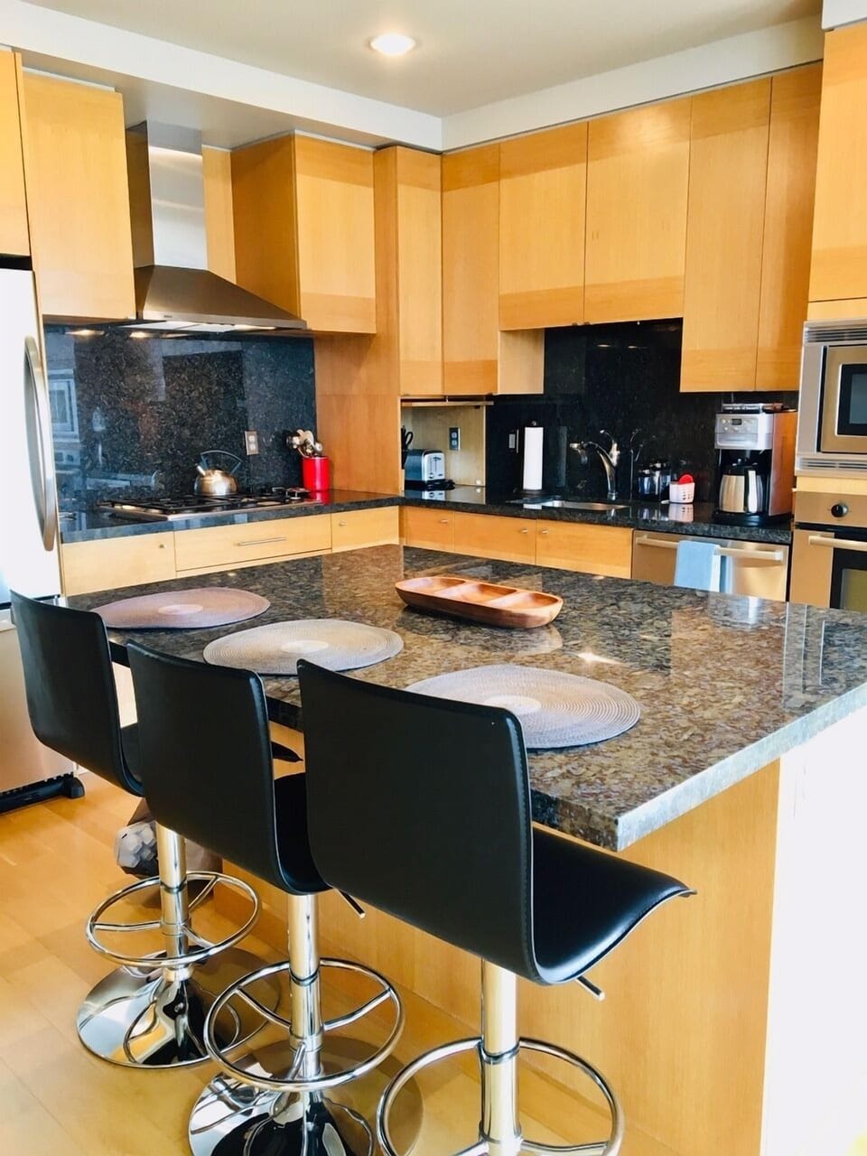 Kitchen is equipped with complete appliances and large granite island