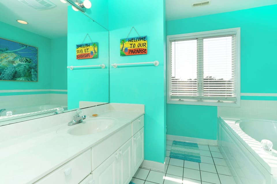 Dive into tropical vibes in your bright, cheerful bathroom with vibrant turquoise walls and ocean-themed touches that make every morning feel like paradise.