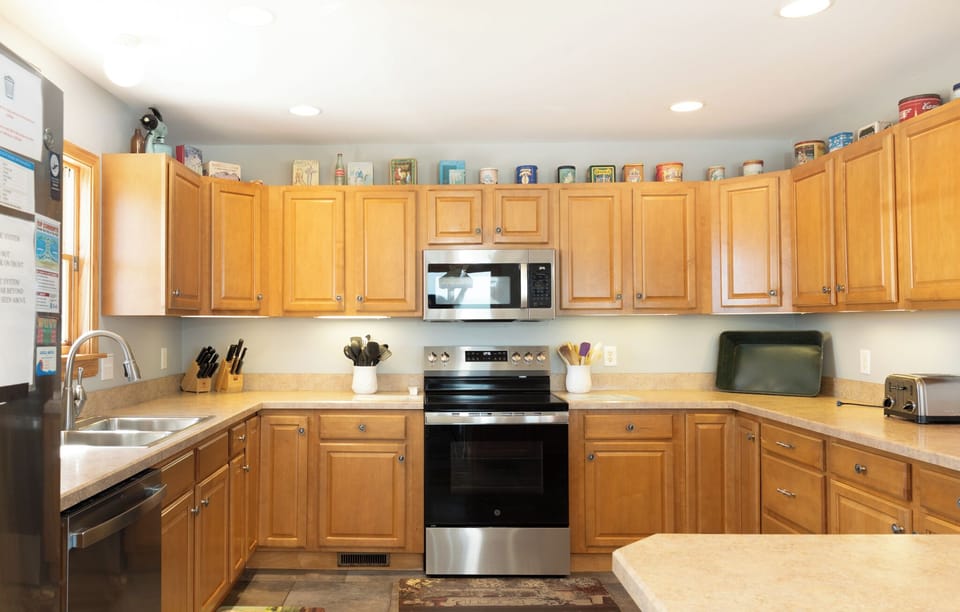 Step into a bright, fully-equipped kitchen with warm wood cabinetry, stainless appliances, and all the essentials you need to prepare your favorite home-cooked meals during your stay.