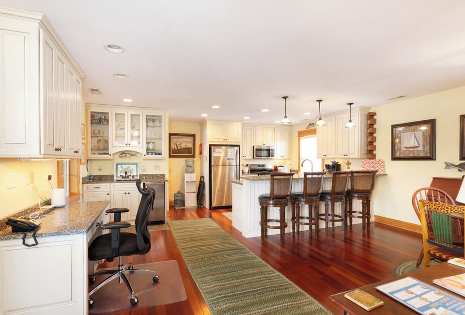 Your spacious kitchen invites you to gather, cook, and connect with gleaming countertops, warm wood floors, and cozy breakfast bar seating bathed in natural light.
