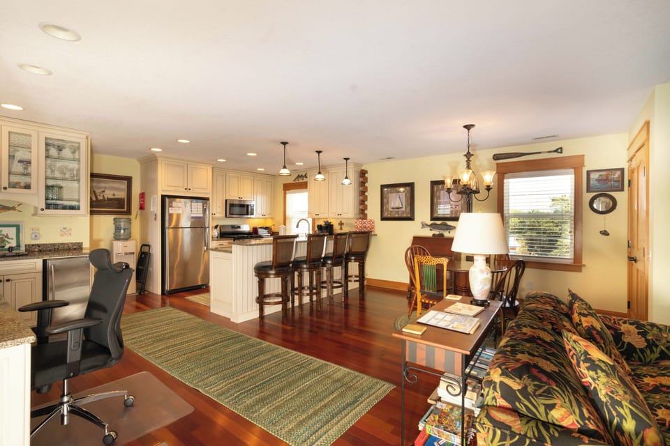 Unwind in this bright open-plan space where gleaming hardwood flows seamlessly from the fully equipped kitchen through the inviting living area. Natural light streams in, highlighting cozy touches perfect for your getaway.
