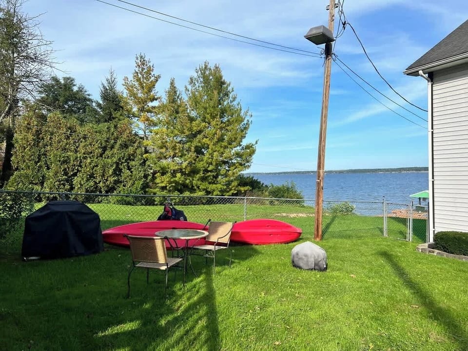 Lakeside lawn with kayaks and plenty of space to relax or play.
