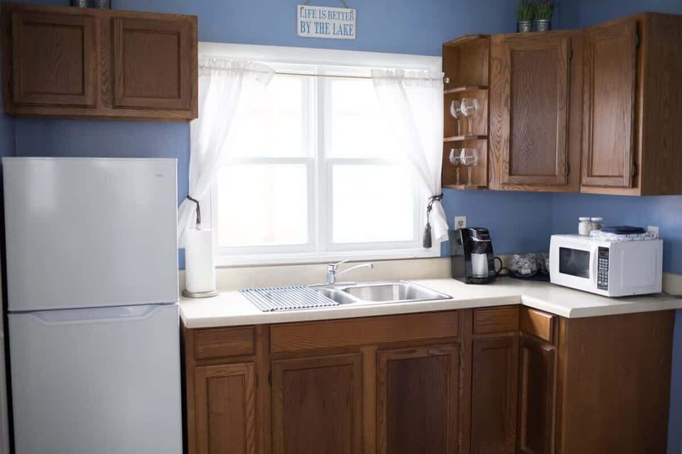 Compact kitchenette with fridge, sink, toaster oven, and essentials—no stove, no problem!