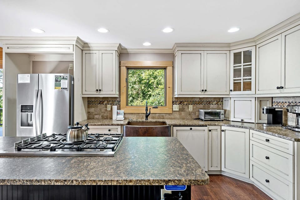 Spacious kitchen with double oven, pantry, oversized copper farm sink, five-burner propane gas stove, and 2 types of coffee makers (Standard Drip & Keurig).