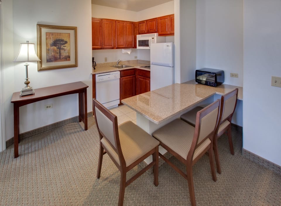 Kitchen with dining table, chairs, and full appliances.