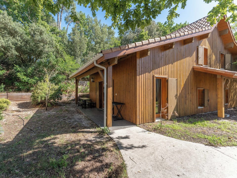 The warm timber exterior of this apartment building, nestled in the pine forest of Les Rives du Lac — a natural, inviting setting just 450 metres from Moutchic Beach.