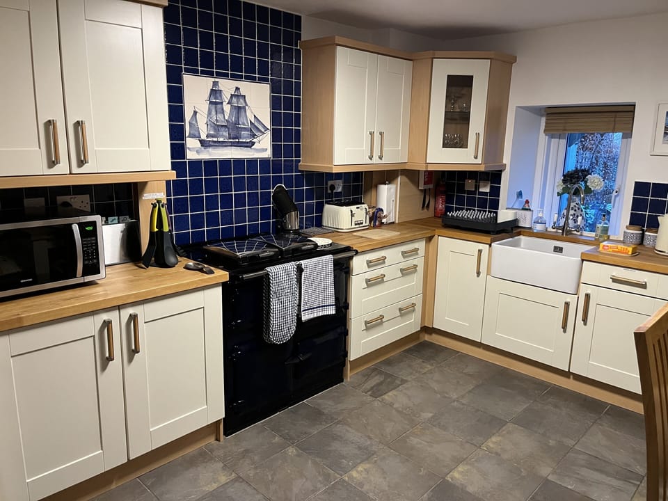 View of the kitchen towards rear window with garden view
