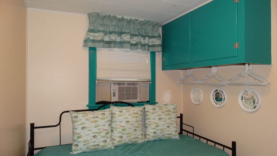 Bedroom 3 - single bed and trundle, overhead cupboard, small dresser