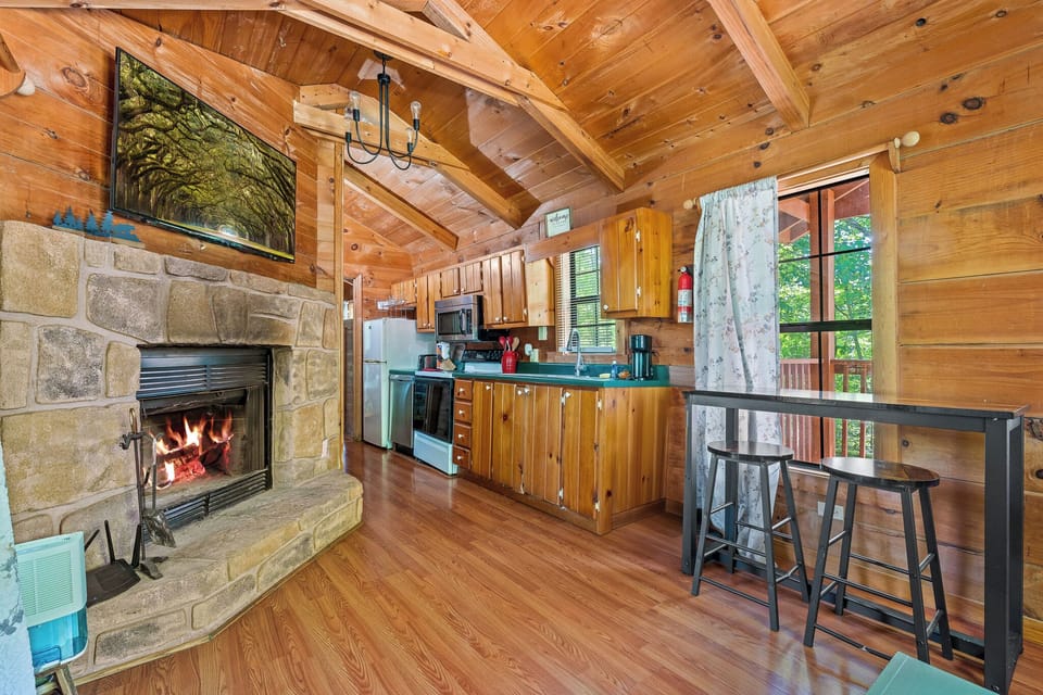 Enjoy a cozy evening by the stone fireplace after cooking in a fully stocked kitchen with modern appliances and rustic charm.