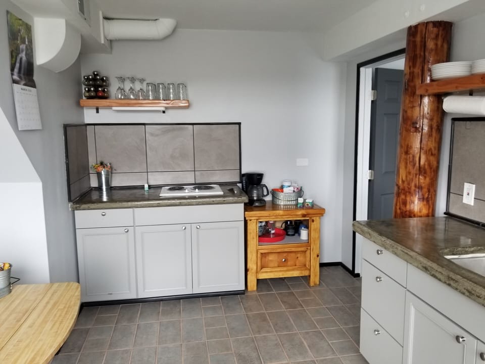 Kitchenette: drinking glasses, stove top, pots and pans, coffee and tea bar.