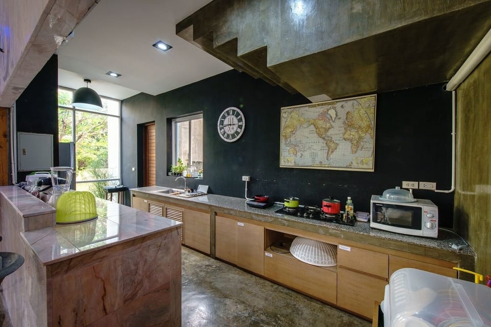 Kitchen fully equipped with microwave, electric cooker and kitchen utensils.