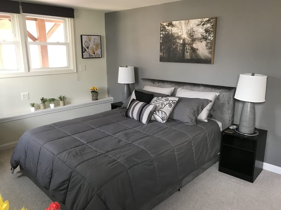Bedroom has 4 windows with blackout roller blinds and bedside multiphone charger