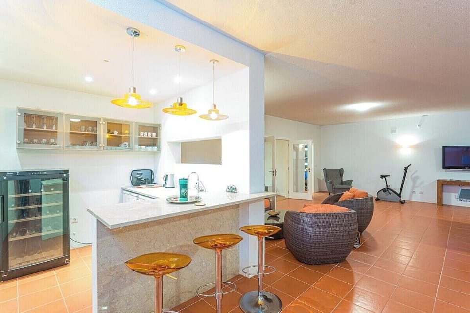 Open-plan kitchen and living area with amber pendant lights — Villa Belga Queen, holiday villa in Cascais