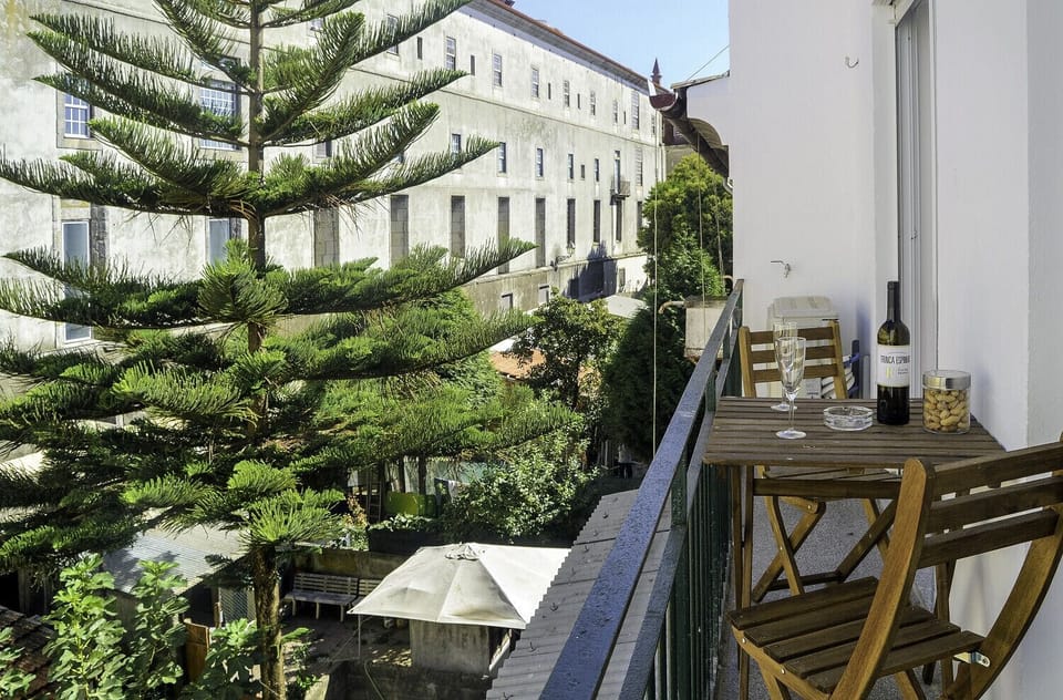Pequena varanda com mesa exterior e vista para a envolvente.