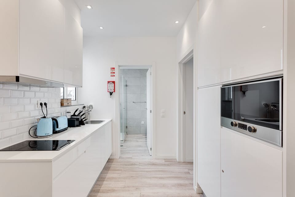 Acesso à kitchenette e zonas funcionais do apartamento.