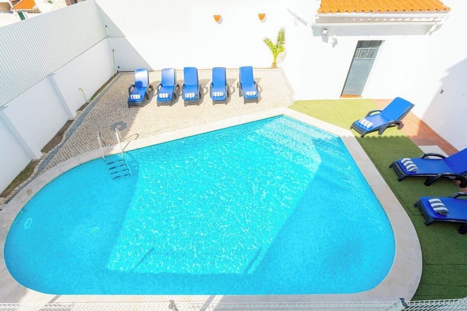 Private pool with blue loungers and terrace — Villa Sol e Mar, holiday villa in Charneca da Caparica