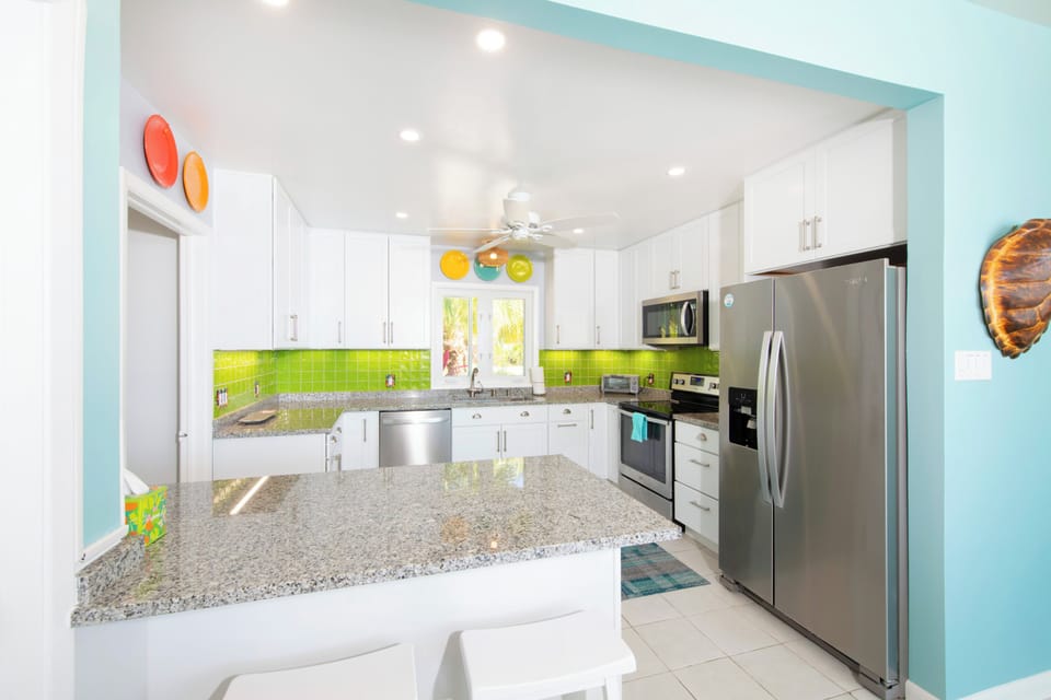 The full kitchen is equipped with modern appliances and breakfast bar seating. 