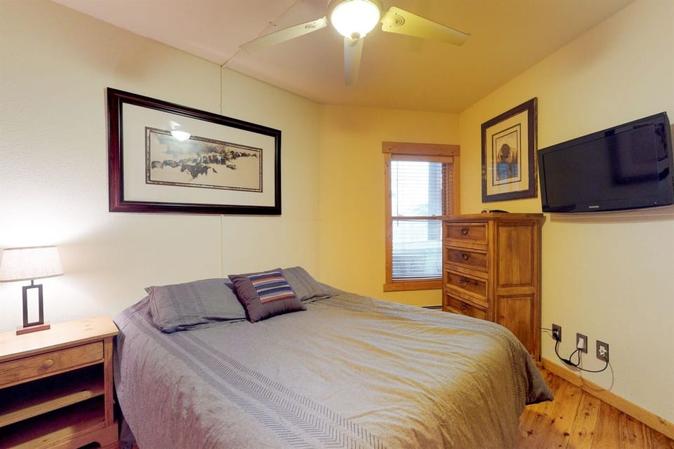 Guest bedroom with a queen bed and tv