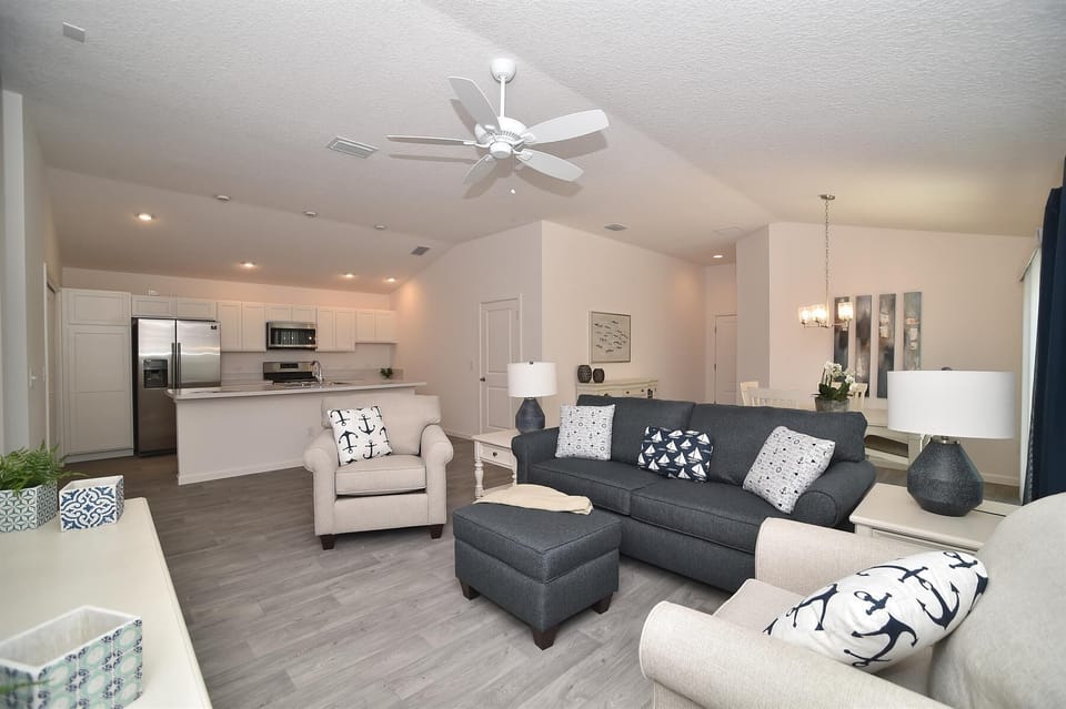 Open concept living/dining/kitchen with 3 bar stools at kitchen island
