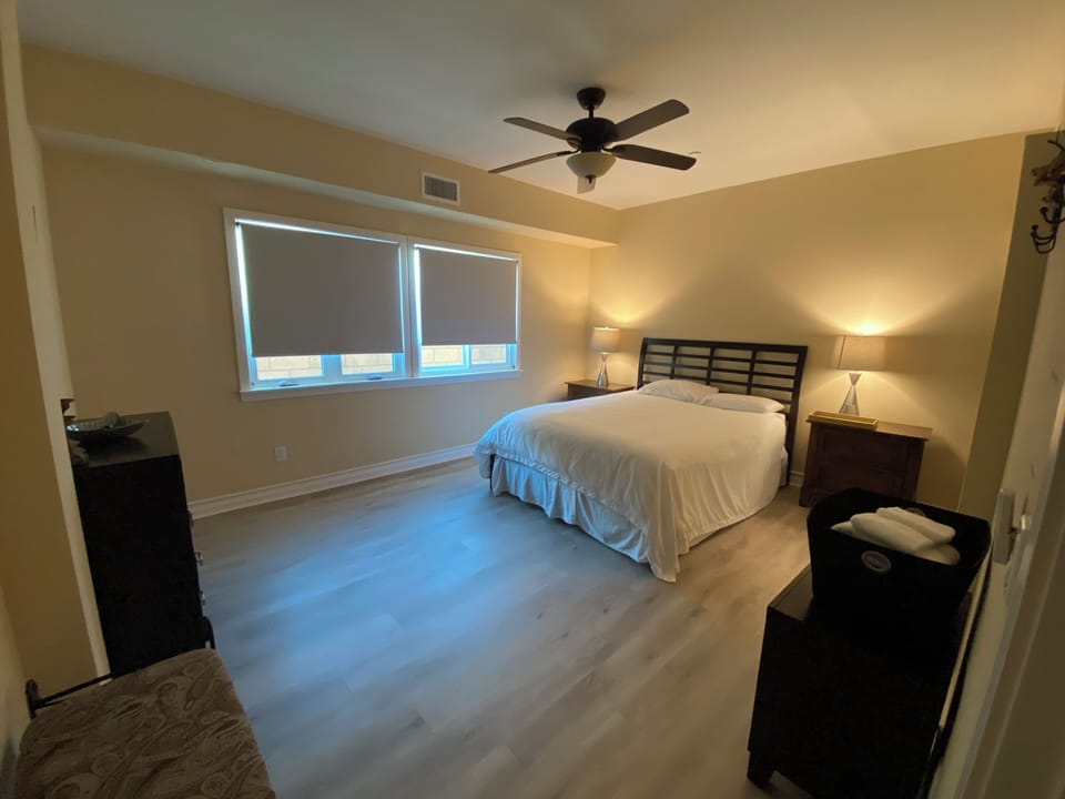 First floor bedroom with queen bed and ceiling fan.