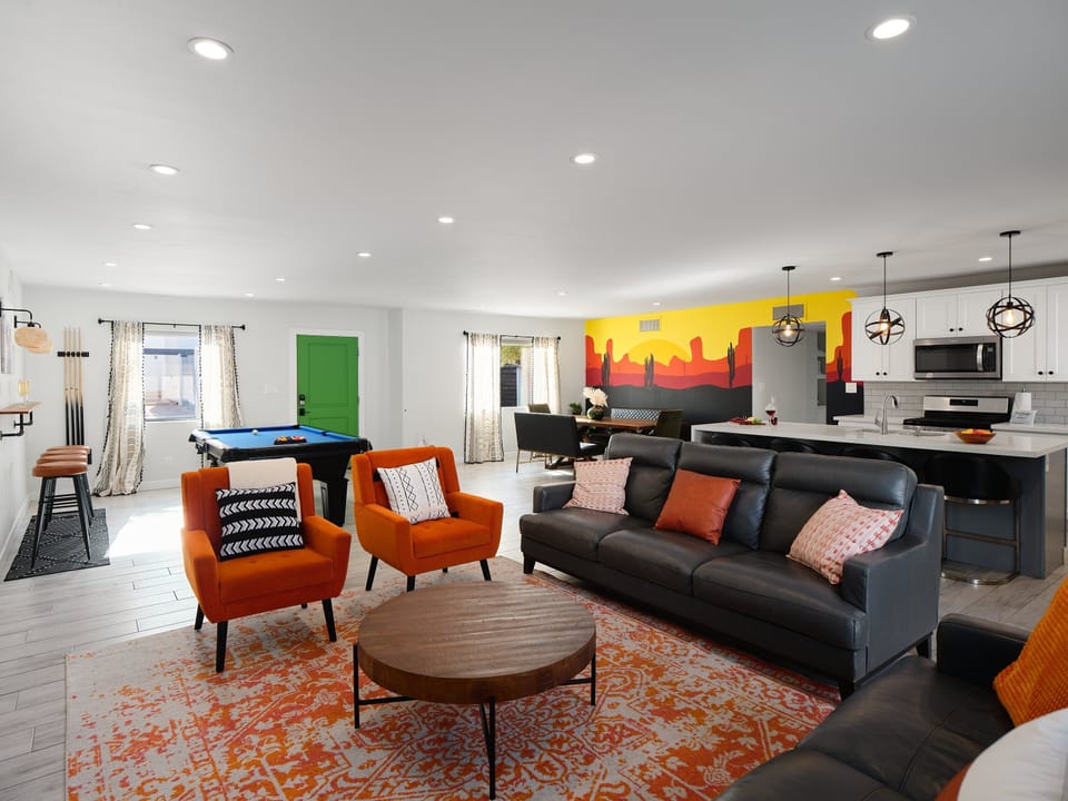 Open concept living area featuring a pool table, dining area, custom accent wall, designer furnishings, and a smart TV.
