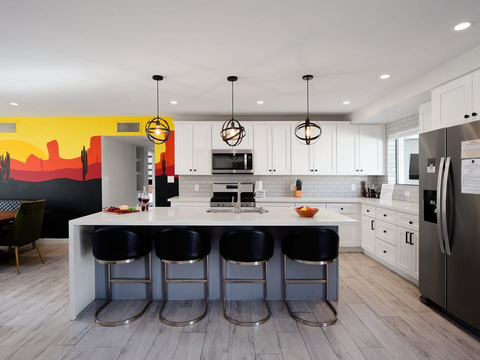 Fully equipped kitchen with stainless steel appliances and breakfast bar seating for 4 guests.