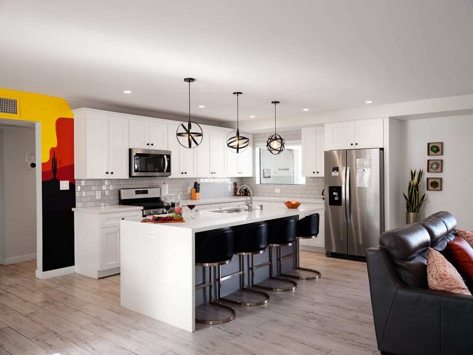 Fully equipped kitchen with stainless steel appliances and breakfast bar seating for 4 guests.