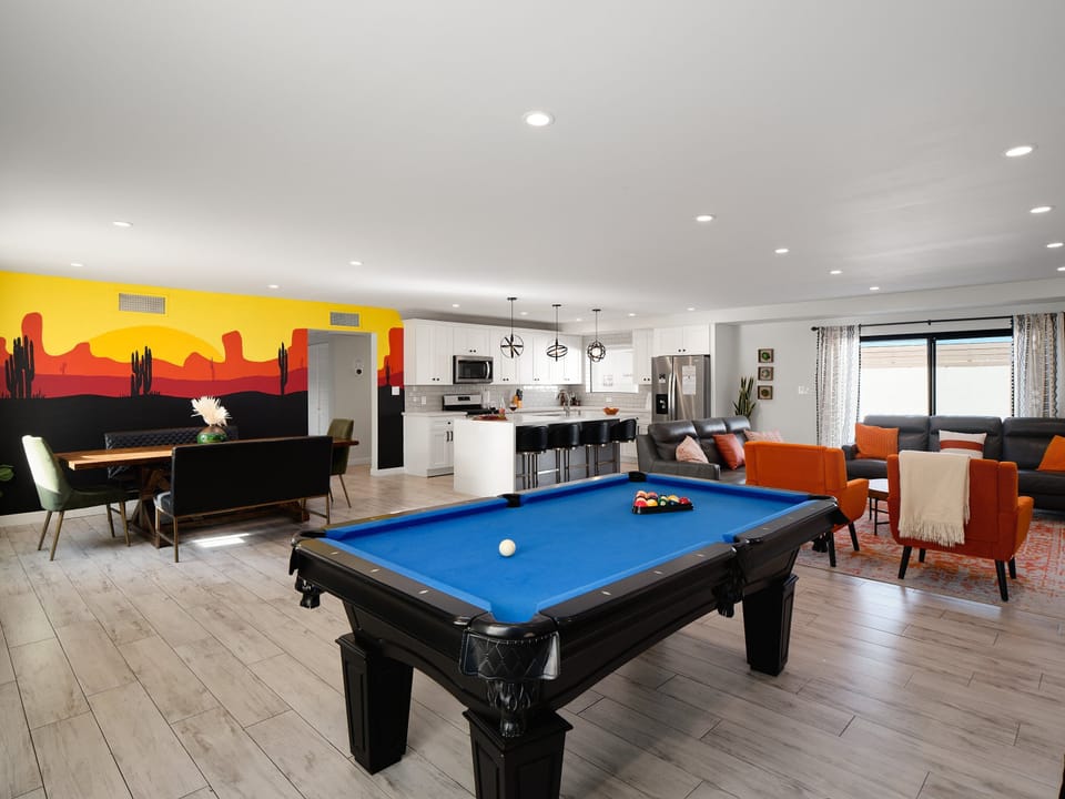 Open concept living area featuring a pool table, dining area, custom accent wall, designer furnishings, and a smart TV.