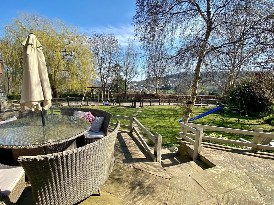 Spacious patio for outdoor dining. Swings, climbing frame, football post.