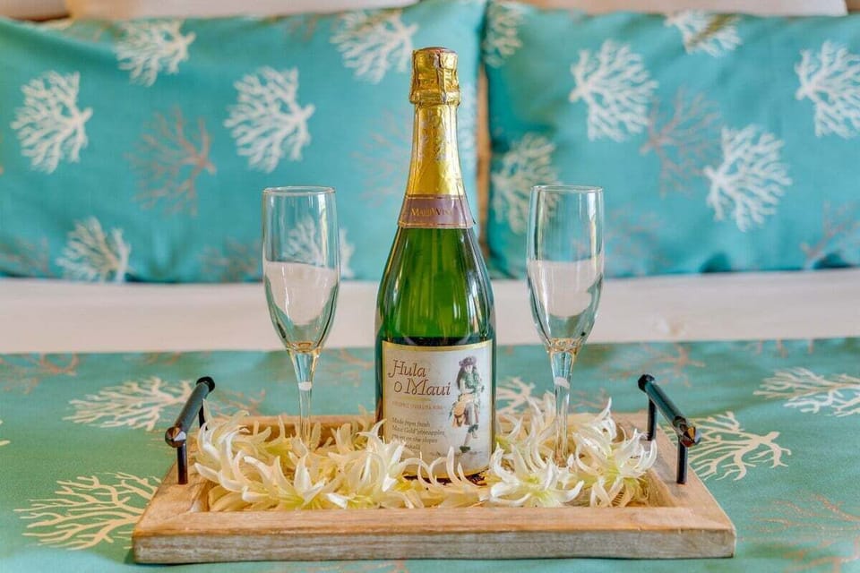 Petals scatter across turquoise bedding, prosecco and flutes waiting for celebration.