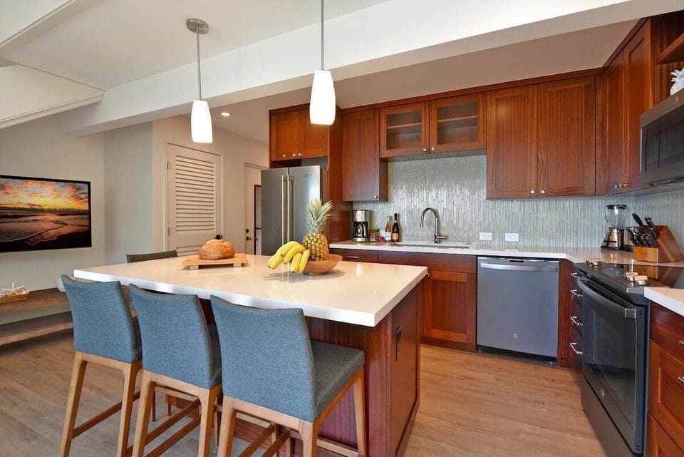 Elegant kitchen with large island, pendant lighting, and modern appliances