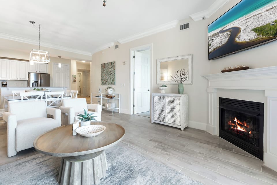 Unwind in your spacious open-concept living area, complete with a cozy fireplace, modern kitchen, and coastal décor that invites relaxation and memorable gatherings.