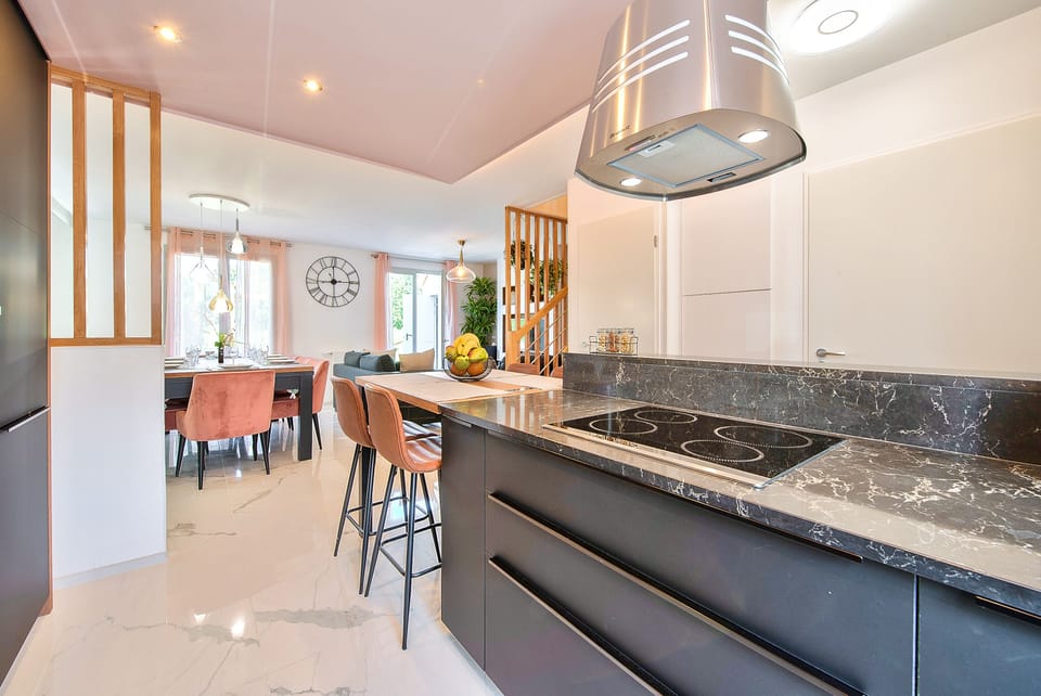 A fully equipped kitchen with a dining area and 4 high chairs, a refrigerator, 