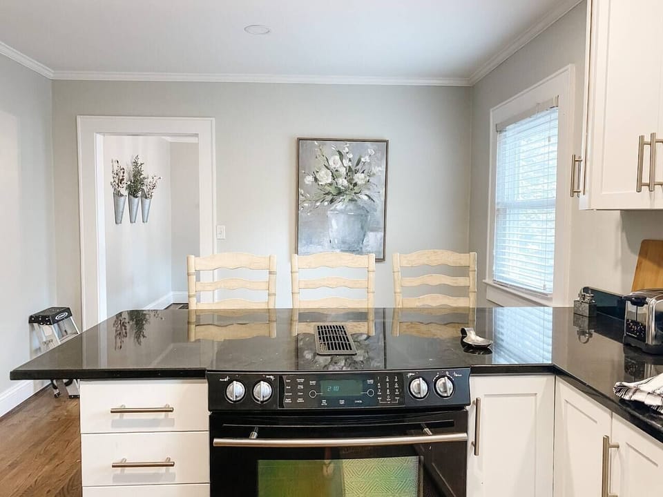 Kitchen: Sleek black countertops and stylish bar seating, perfect for breakfast banter!