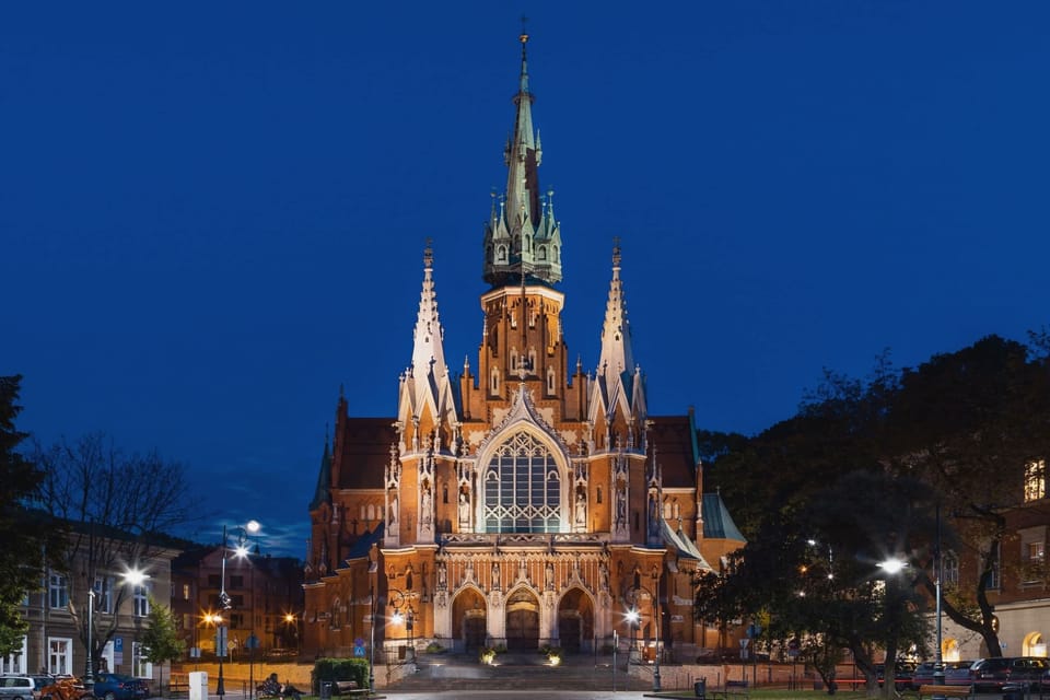 A stunning nighttime view of a brightly lit cathedral against a dark sky, showcasing intricate architectural details.
